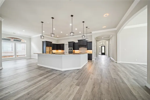 a living room with stainless steel appliances kitchen island wooden floors and view kitchen