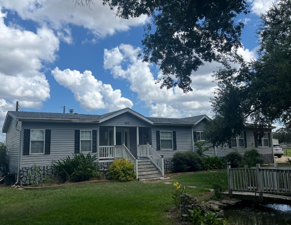1873 FM 1163 Road El Campo, TX 77437 - Photo 1 of 48 a front view of a house with a garden
