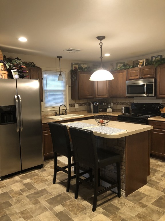 1873 FM 1163 Road El Campo, TX 77437 - Photo 29 of 48 a kitchen with stainless steel appliances granite countertop a sink a stove and a refrigerator
