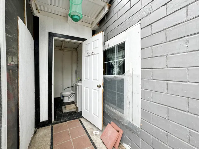 a backyard of a house with potted plants and a large tree
