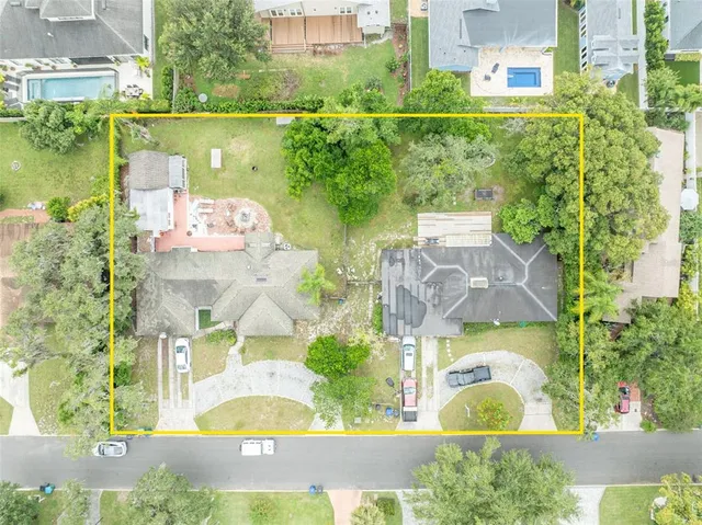 an aerial view of residential houses with outdoor space and lake view