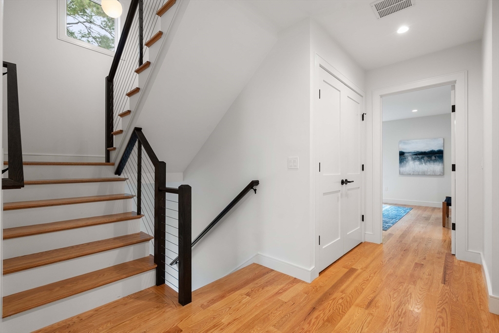 110 Harvard Street, Unit A Newton, MA 02460 - Photo 14 of 30 a view of a hallway with wooden floor and staircase
