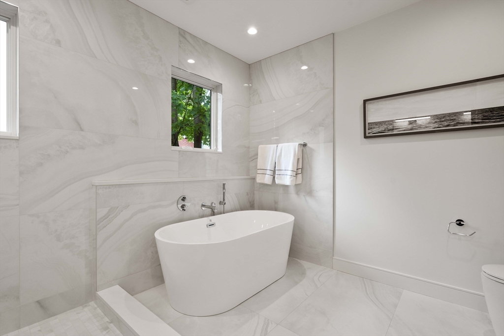110 Harvard Street, Unit A Newton, MA 02460 - Photo 16 of 30 a white bath tub sitting in a bathroom next to a window