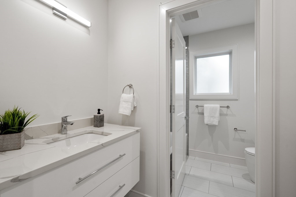 110 Harvard Street, Unit A Newton, MA 02460 - Photo 20 of 30 a bathroom with a sink vanity granite and a mirror