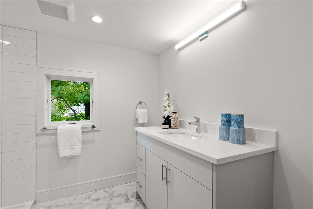 110 Harvard Street, Unit A Newton, MA 02460 - Photo 23 of 30 a bathroom with a sink and a mirror