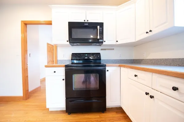 a kitchen with white cabinets and appliances