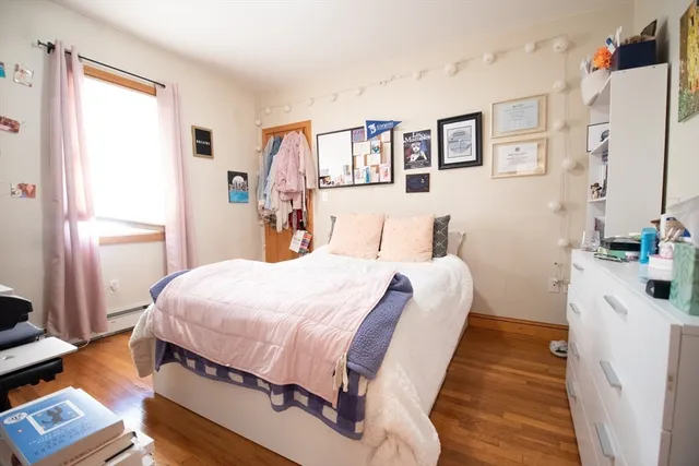 a bedroom with bed and wooden floor