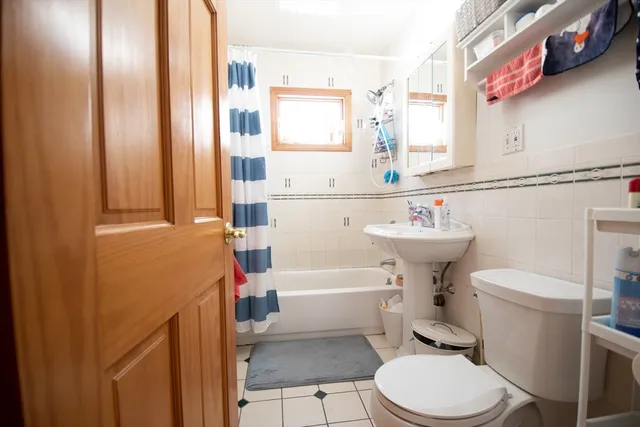 a bathroom with a sink a toilet and shower curtain