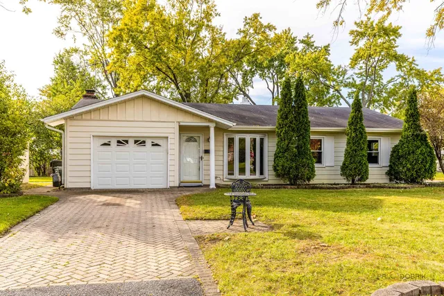 a front view of a house with a yard table and chairs