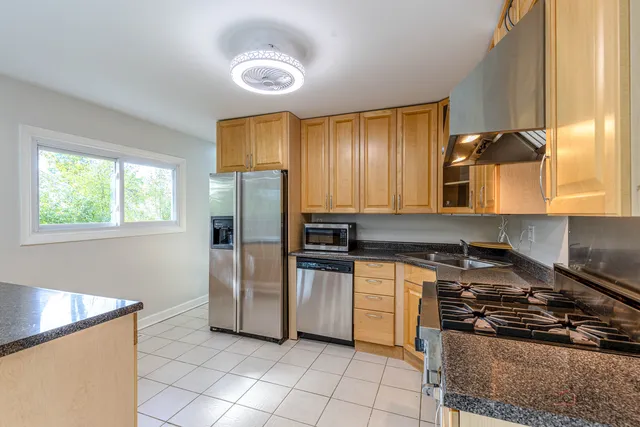 a kitchen with a stove a refrigerator and a window