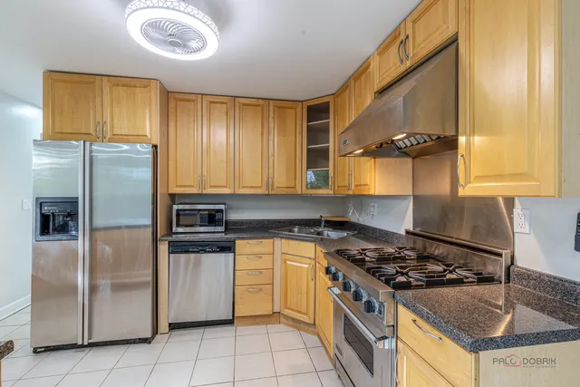 a kitchen with stainless steel appliances granite countertop a stove a refrigerator and a sink