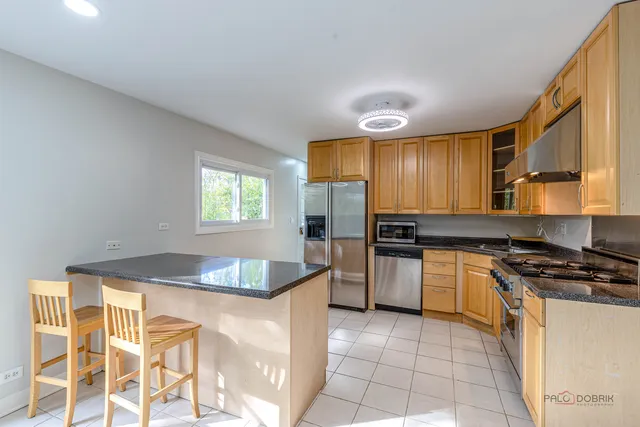 a kitchen with granite countertop cabinets stainless steel appliances and a counter space