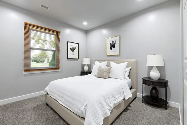 a large bed sitting in a bedroom next to a window