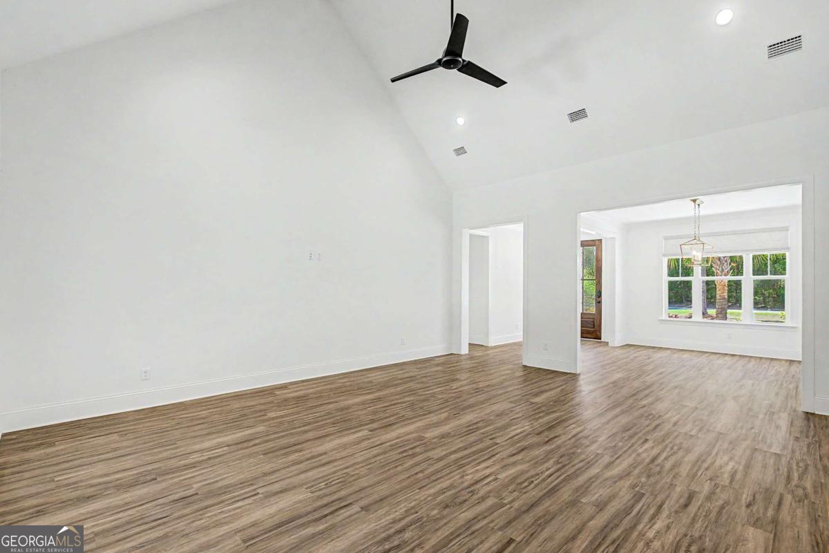 656 Sanderling Trace Waverly, GA 31565 - Photo 11 of 71 a view of an empty room with wooden floor and a window