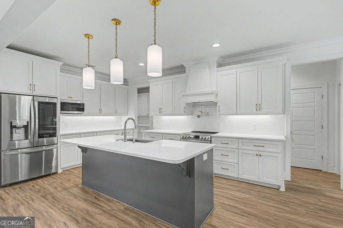 656 Sanderling Trace Waverly, GA 31565 - Photo 12 of 71 a kitchen with kitchen island a stove a sink a center island and wooden floor