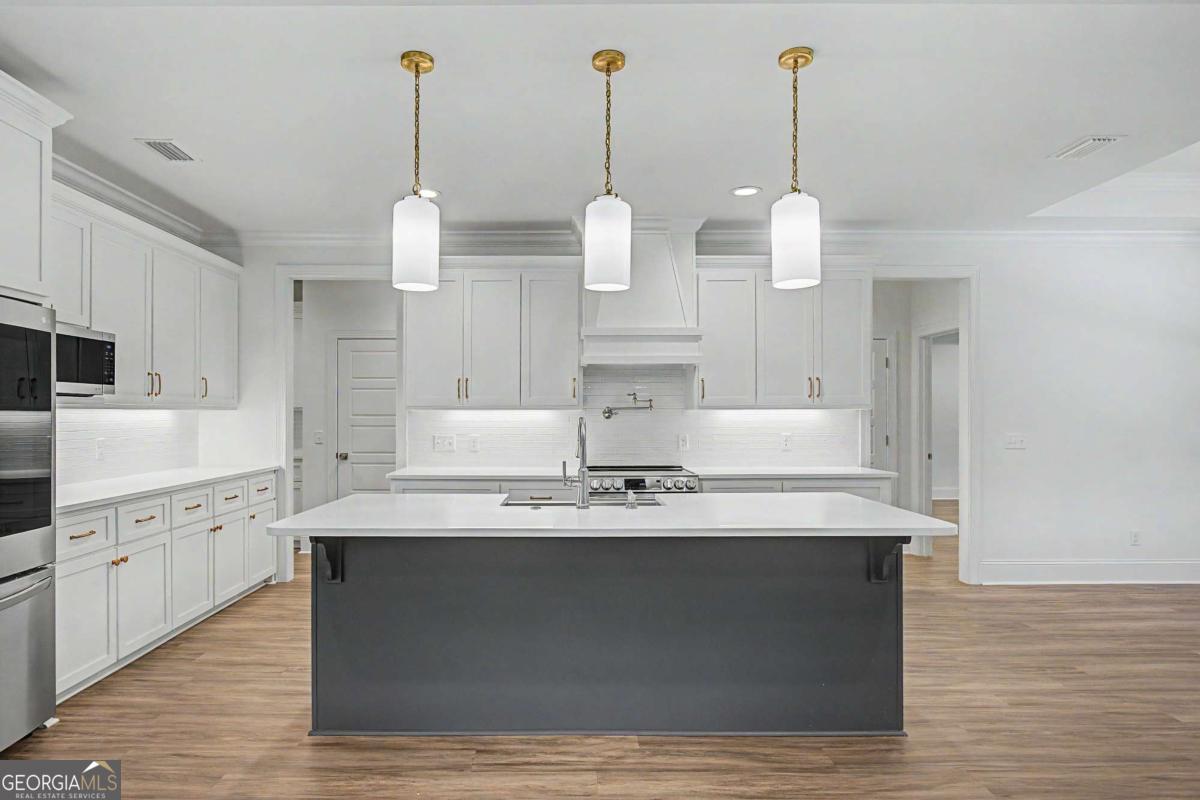 656 Sanderling Trace Waverly, GA 31565 - Photo 13 of 71 a large kitchen with granite countertop a stove a sink a center island and wooden floor