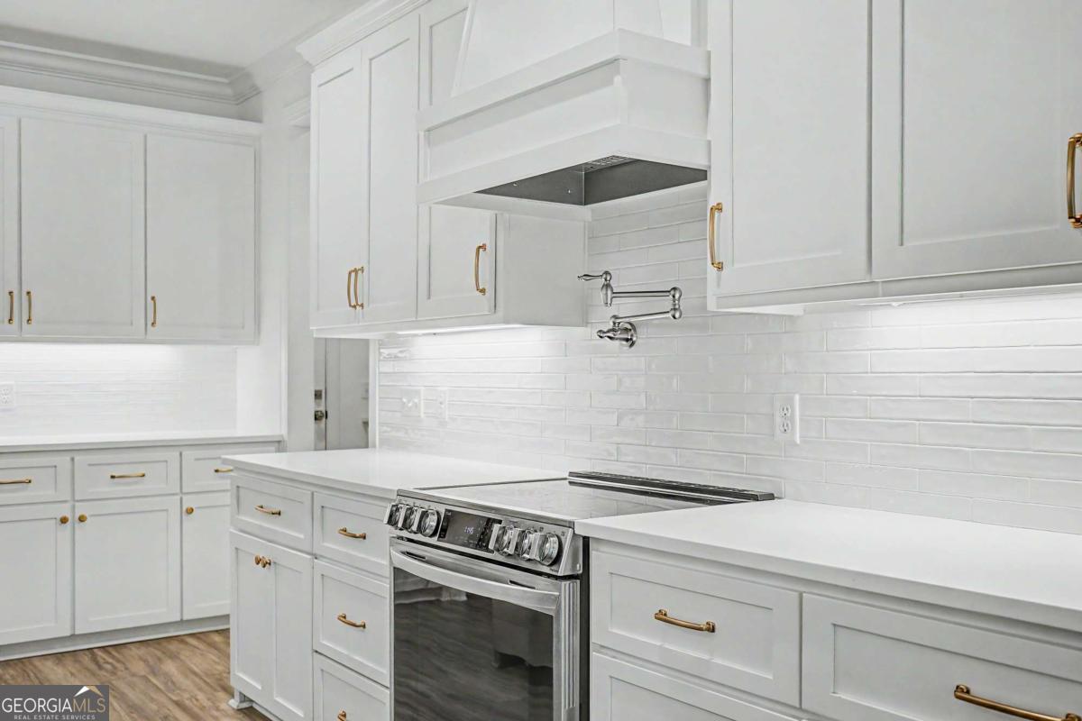656 Sanderling Trace Waverly, GA 31565 - Photo 14 of 71 a kitchen with white cabinets and appliances