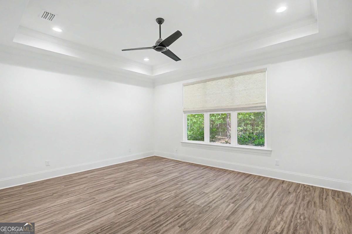 656 Sanderling Trace Waverly, GA 31565 - Photo 19 of 71 an empty room with wooden floor fan and windows