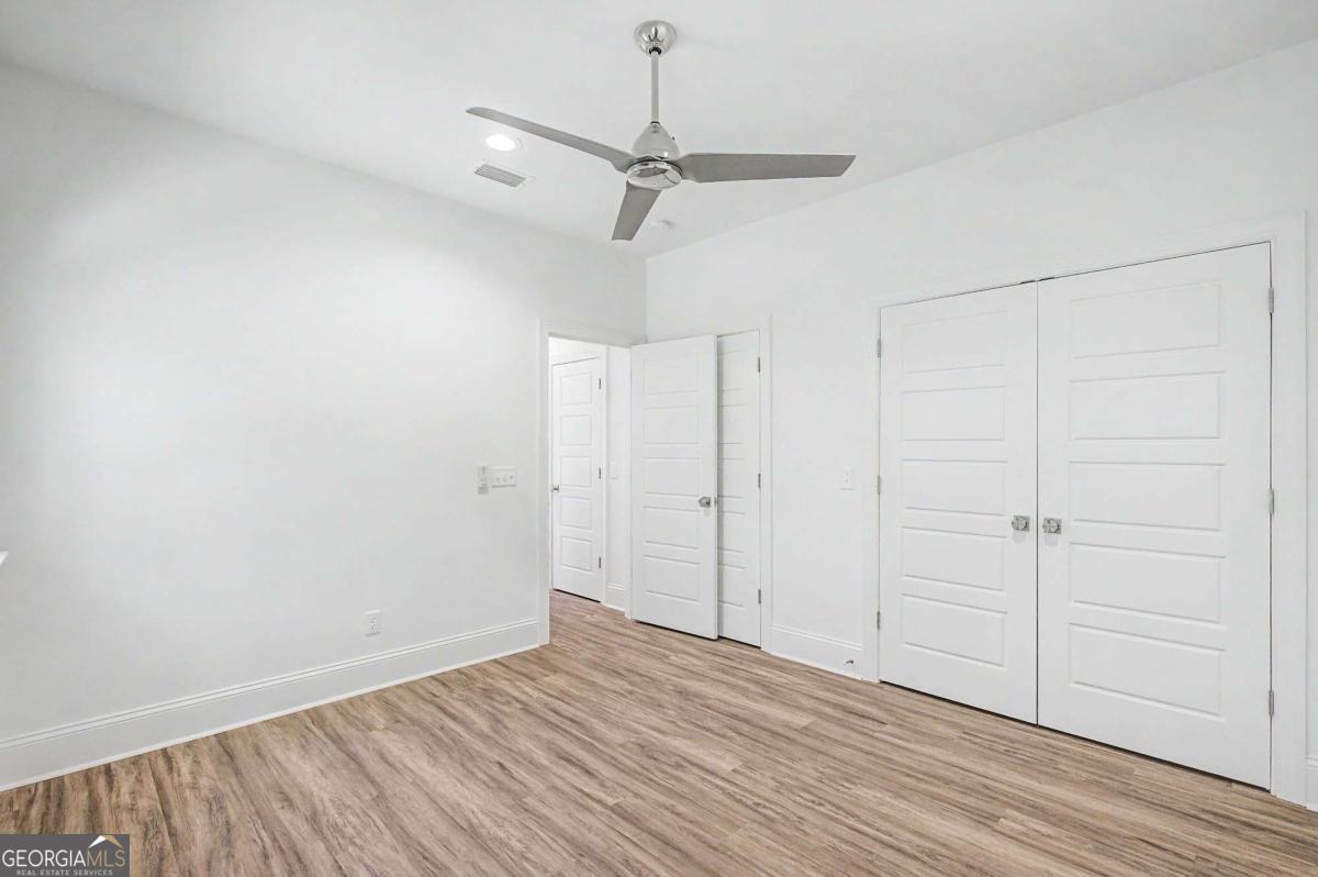 656 Sanderling Trace Waverly, GA 31565 - Photo 29 of 71 a view of a room with wooden floor closet and ceiling fan
