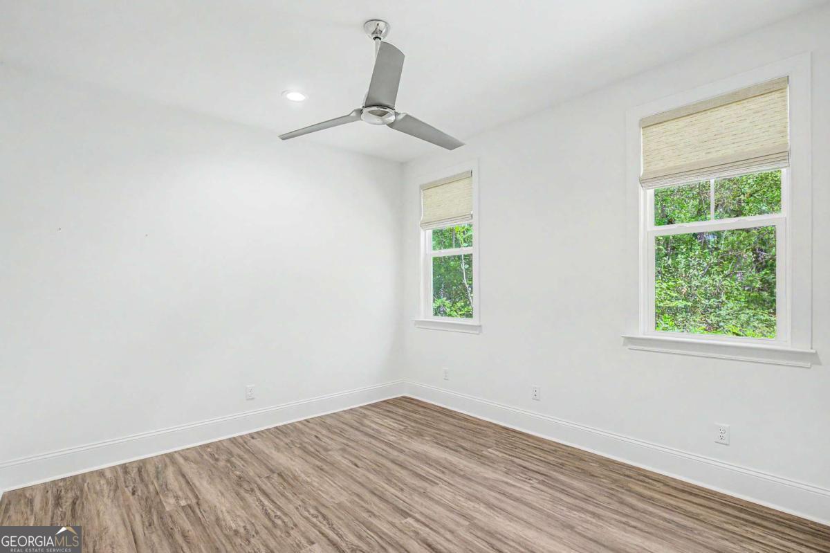 656 Sanderling Trace Waverly, GA 31565 - Photo 30 of 71 an empty room with wooden floor fan and windows