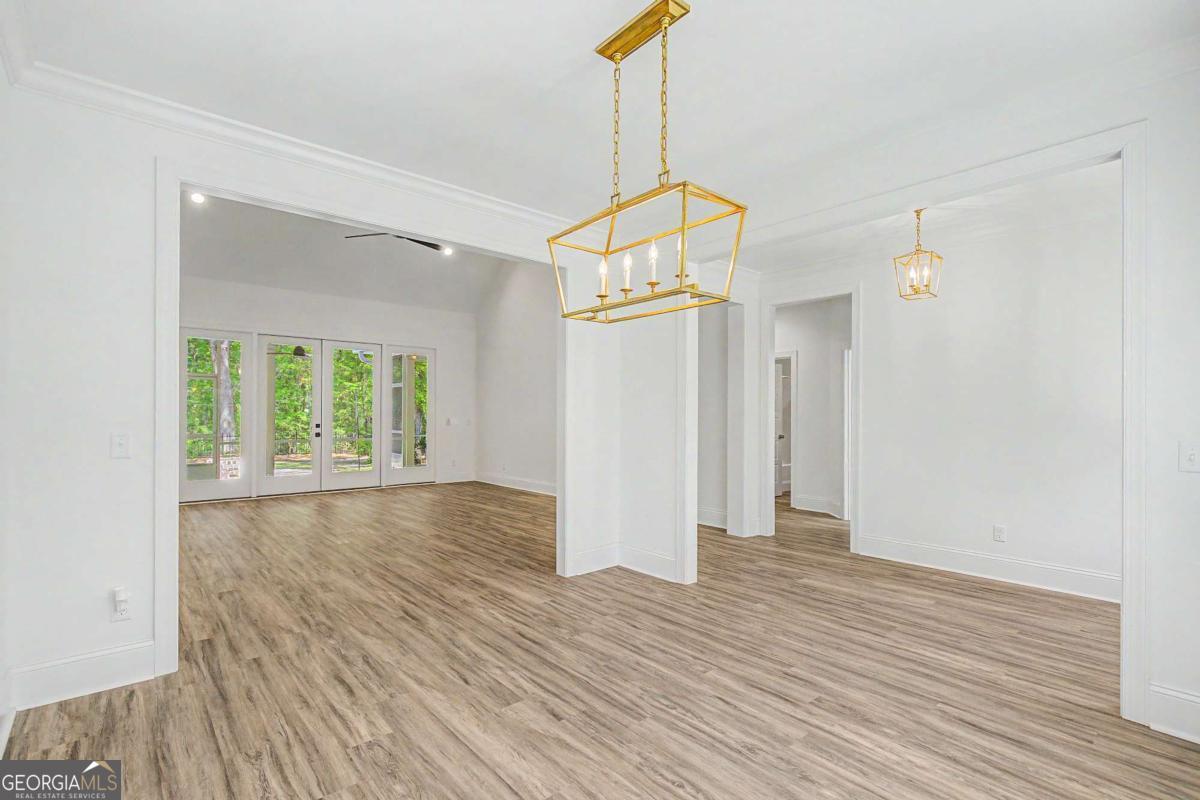 656 Sanderling Trace Waverly, GA 31565 - Photo 6 of 71 a view of empty room with wooden floor and windows