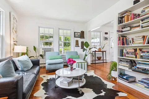 a living room with furniture and a book shelf