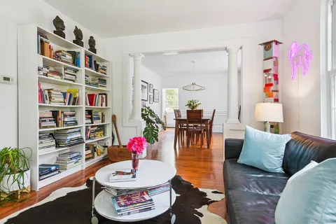 a living room with furniture and a book shelf