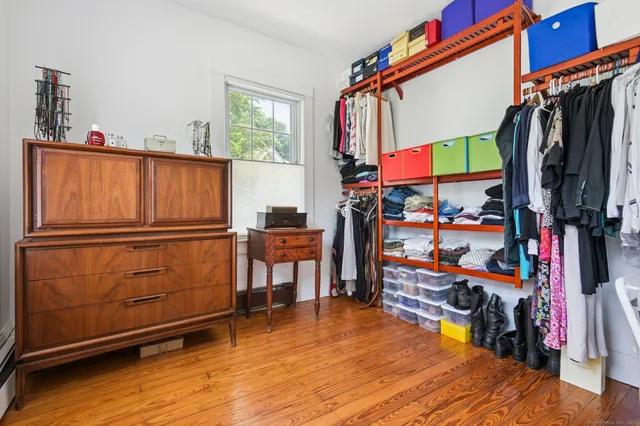 a view of walk in closet with clothes and shoes