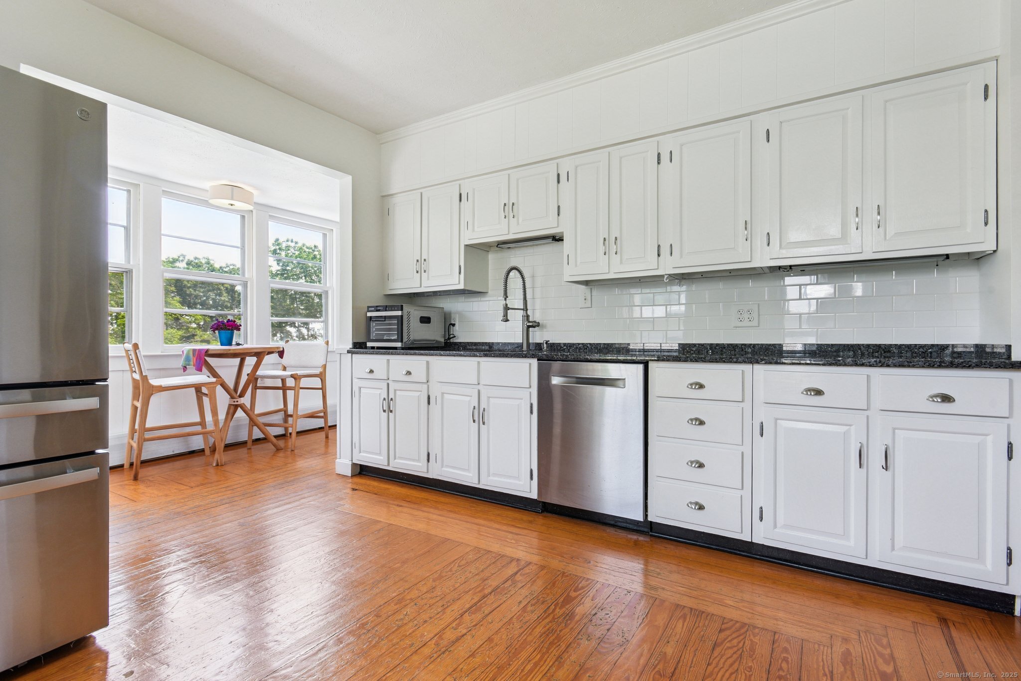 24 Warren Avenue Mystic, CT 06355 - Photo 7 of 37 a kitchen with granite countertop white cabinets sink and stainless steel appliances