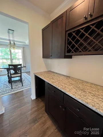 a kitchen with wooden cabinets and wooden floor