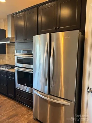 a metallic refrigerator freezer sitting in a kitchen