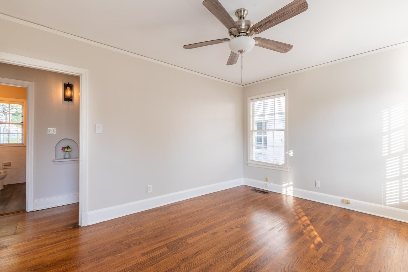 380 Holmes Circle Memphis, TN 38111 - Photo 19 of 22 an empty room with wooden floor fan and windows