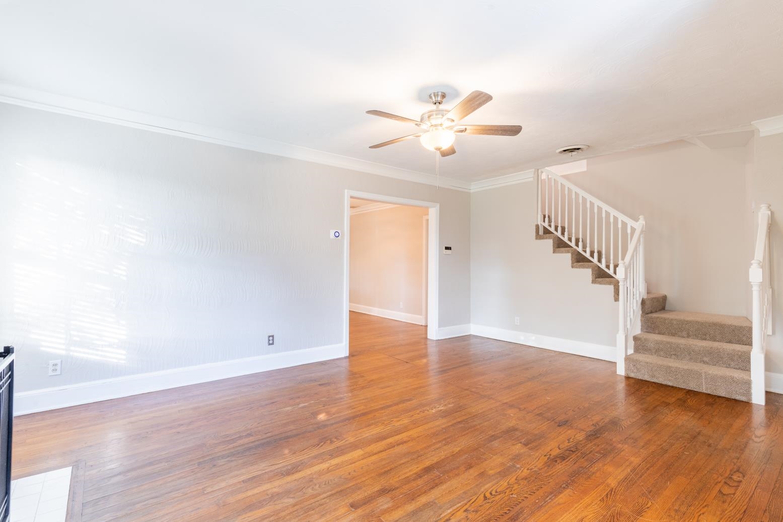 380 Holmes Circle Memphis, TN 38111 - Photo 6 of 22 a view of an empty room with wooden floor and a ceiling fan