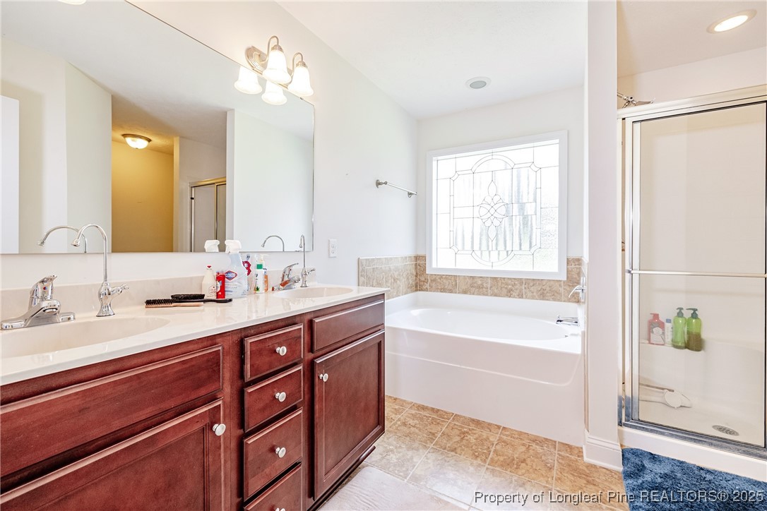 3453 Thrower Road Hope Mills, NC 28348 - Photo 15 of 24 a spacious bathroom with a tub sink and mirror