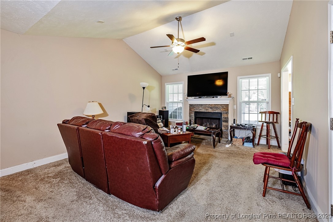 3453 Thrower Road Hope Mills, NC 28348 - Photo 5 of 24 a living room with furniture a flat screen tv and a fireplace