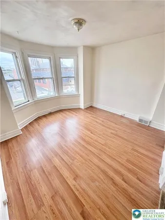 a view of empty room with wooden floor