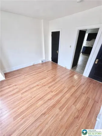 a view of empty room with wooden floor