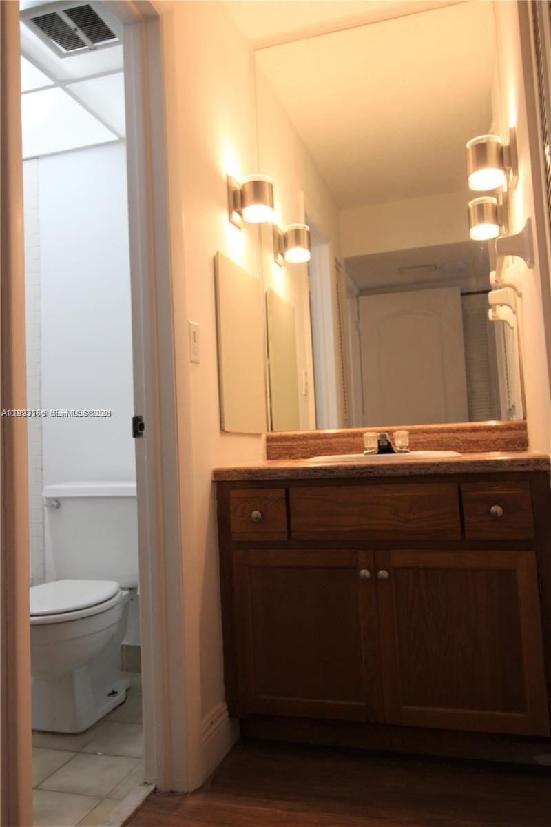 3690 Inverrary Drive, Unit 3A Lauderhill, FL 33319 - Photo 12 of 18 a bathroom with a sink a toilet and a mirror