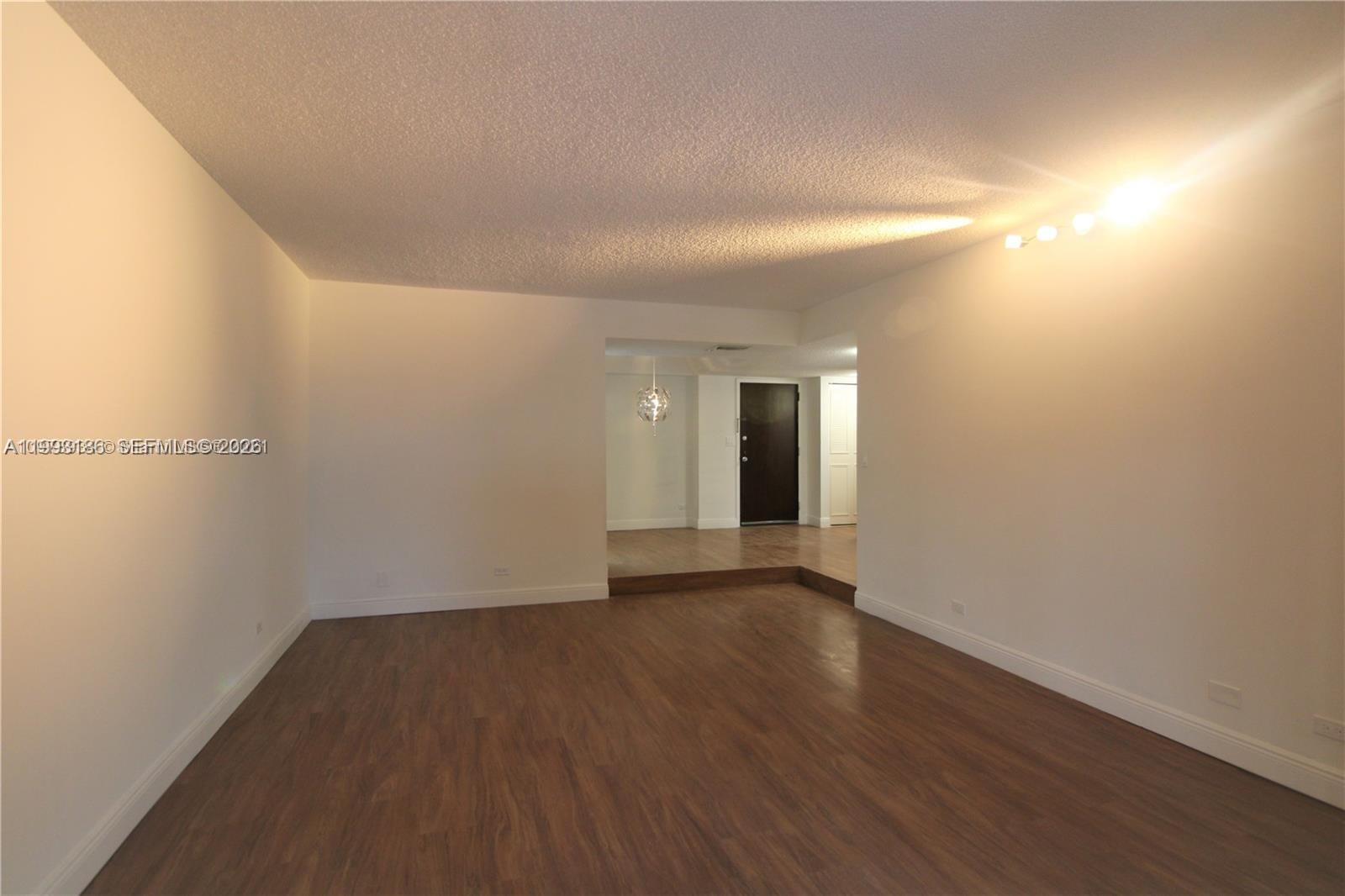 3690 Inverrary Drive, Unit 3A Lauderhill, FL 33319 - Photo 4 of 18 a view of an empty room with wooden floor and a window