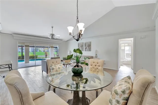 a dining room with furniture a potted plant and a chandelier