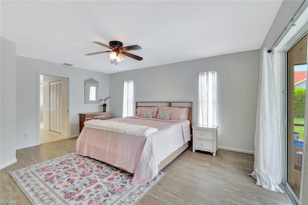 5859 Westbourgh Court Naples, FL 34112 - Photo 12 of 25 a bedroom with a bed and a chandelier