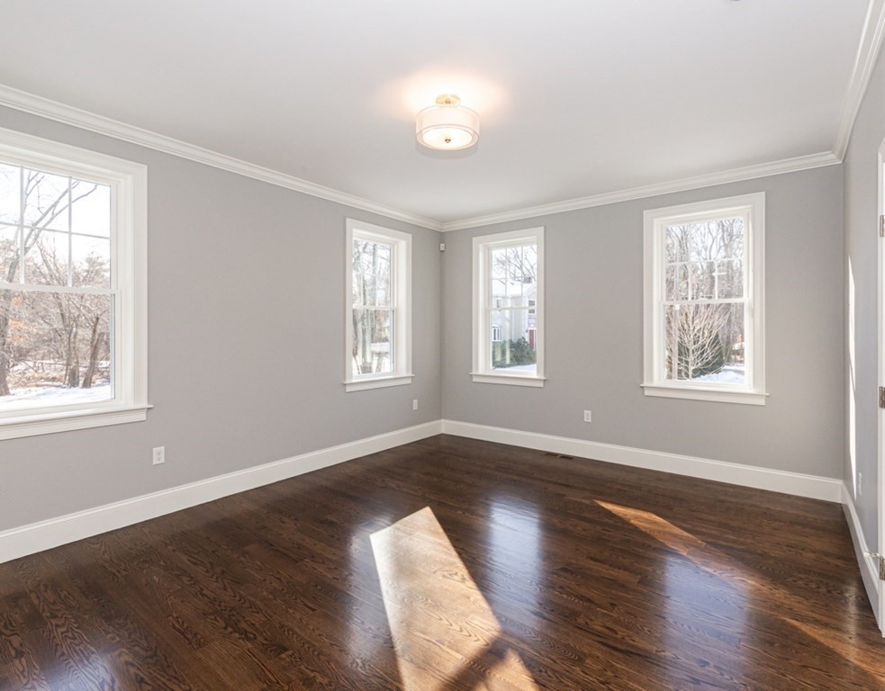 16 Jonathan Lane Bedford, MA 01730 - Photo 14 of 42 a view of an empty room with wooden floor and windows