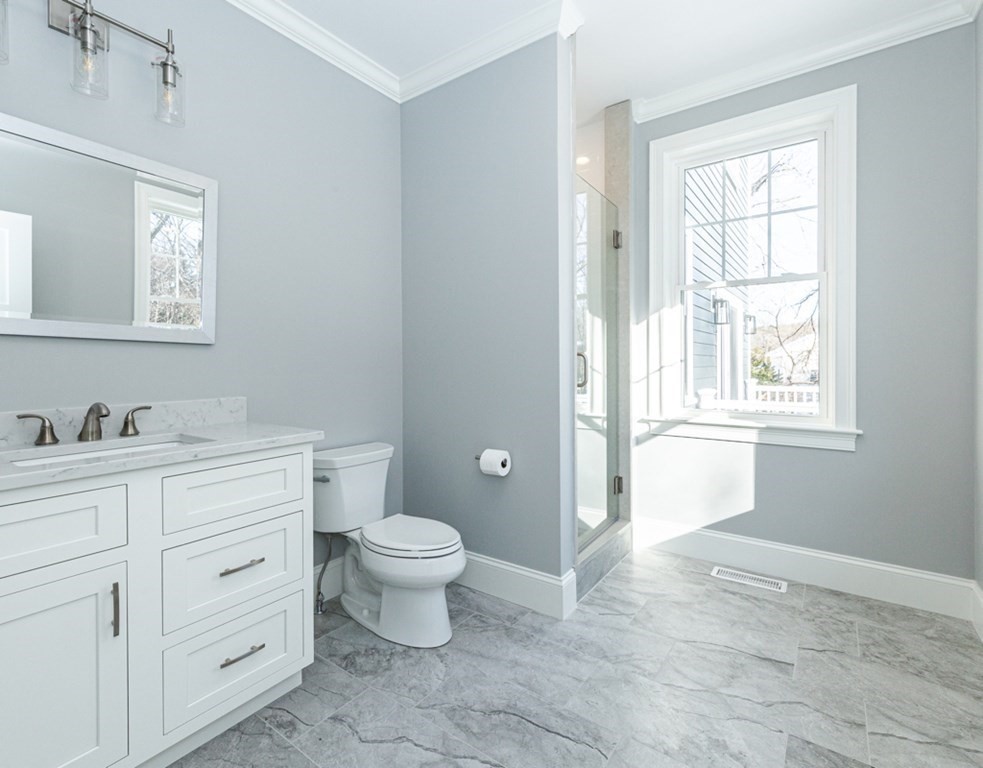 16 Jonathan Lane Bedford, MA 01730 - Photo 16 of 42 a bathroom with a granite countertop toilet a sink a mirror and a window