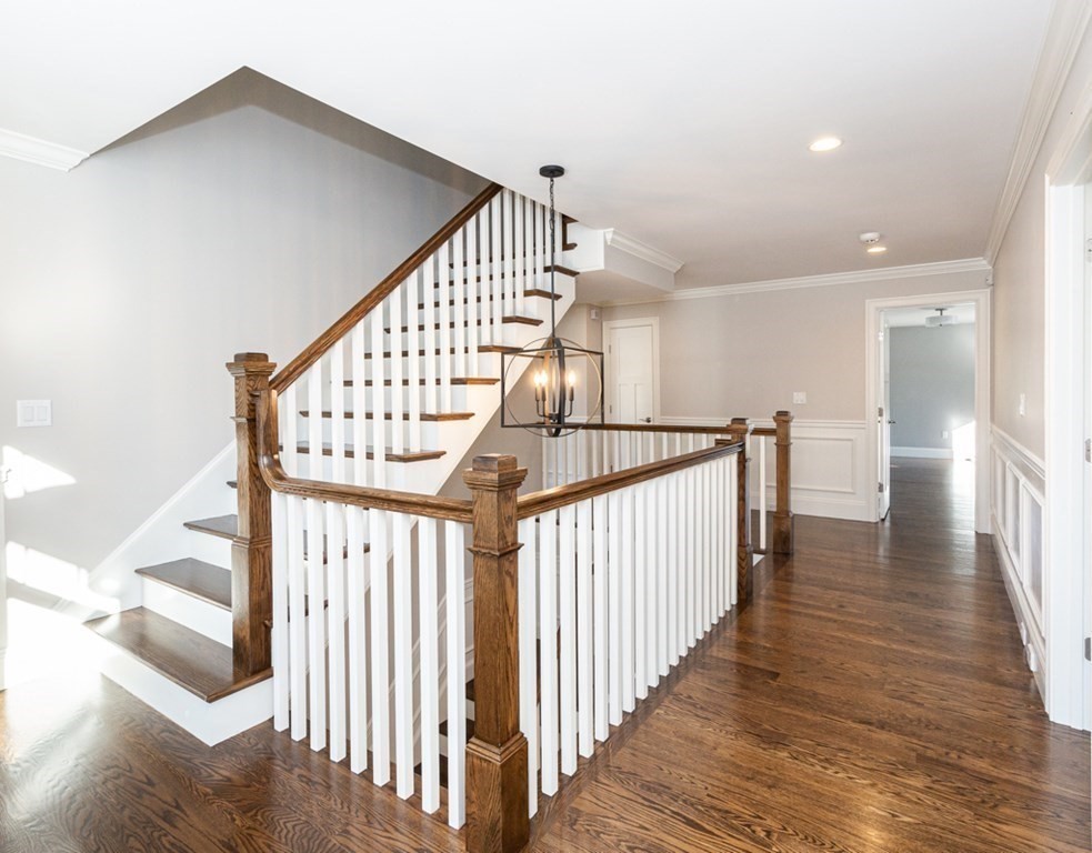 16 Jonathan Lane Bedford, MA 01730 - Photo 18 of 42 a view of staircase with wooden floor and white walls