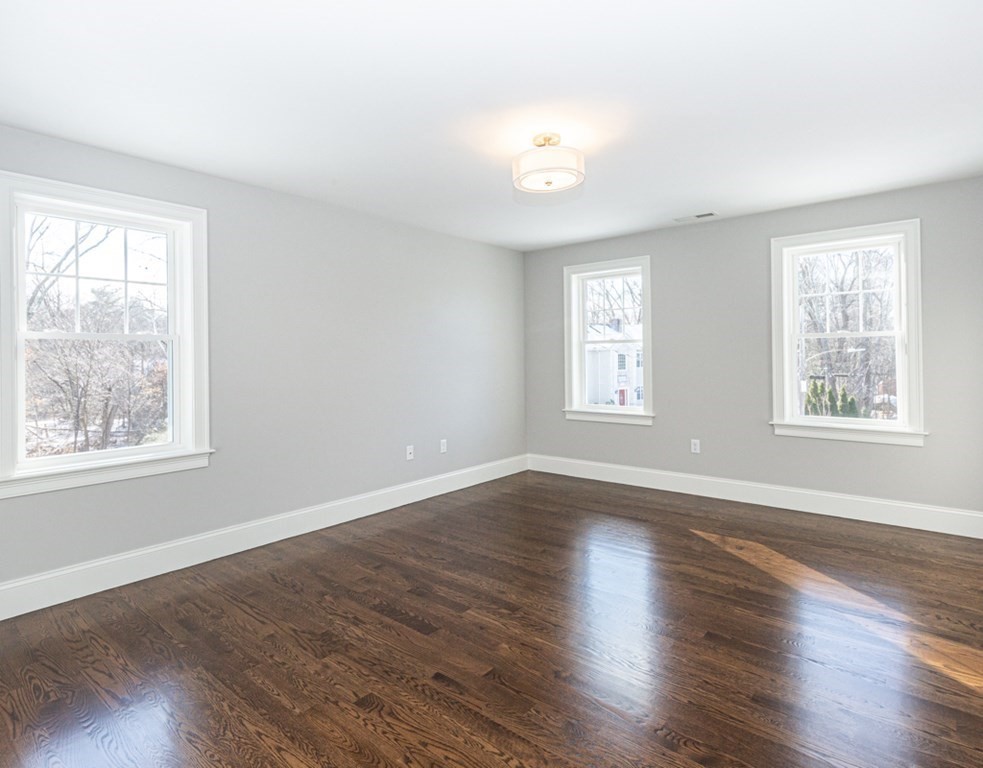 16 Jonathan Lane Bedford, MA 01730 - Photo 19 of 42 a view of an empty room with wooden floor and a window