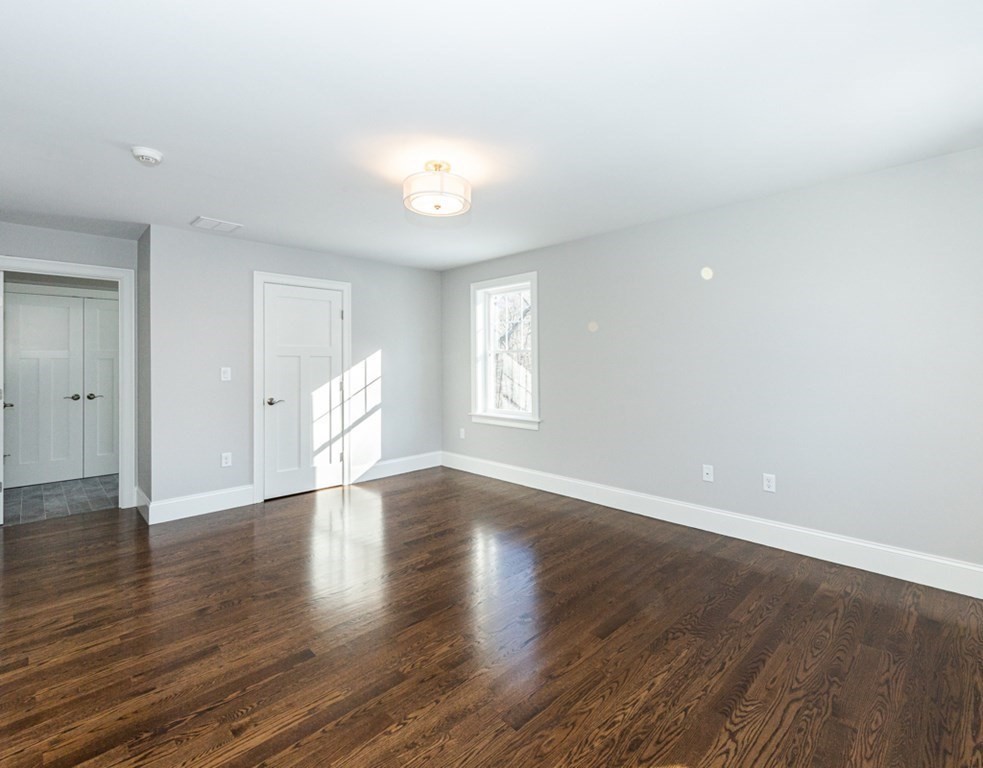 16 Jonathan Lane Bedford, MA 01730 - Photo 20 of 42 a view of an empty room with wooden floor and window