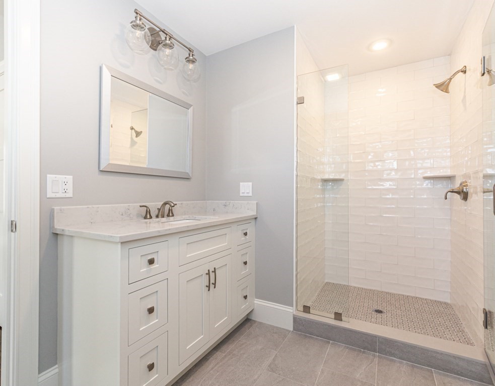 16 Jonathan Lane Bedford, MA 01730 - Photo 23 of 42 a bathroom with a shower sink and mirror