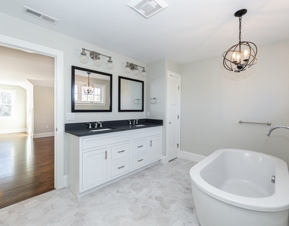 16 Jonathan Lane Bedford, MA 01730 - Photo 28 of 42 a spacious bathroom with a granite countertop sink and a large mirror
