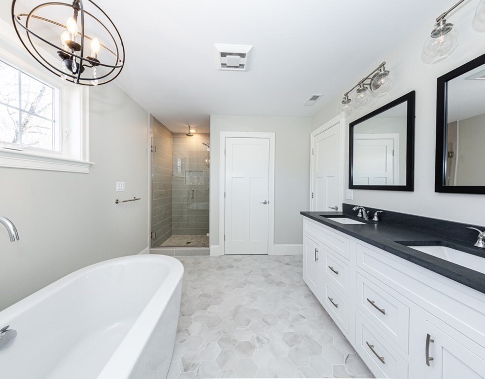 16 Jonathan Lane Bedford, MA 01730 - Photo 29 of 42 a bathroom with a granite countertop sink a mirror and a bathtub