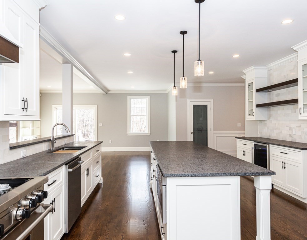 16 Jonathan Lane Bedford, MA 01730 - Photo 9 of 42 a kitchen with stainless steel appliances granite countertop a sink a stove and a wooden floors